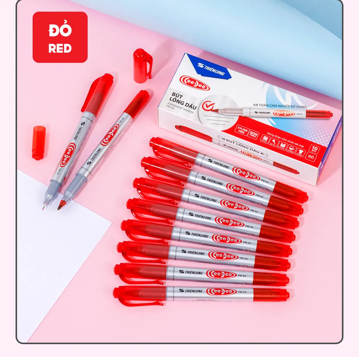 Hộp và các cây bút lông dầu Thiên Long PM-04 màu đỏ với thiết kế 2 đầu tiện lợi đặt trên nền hồng.