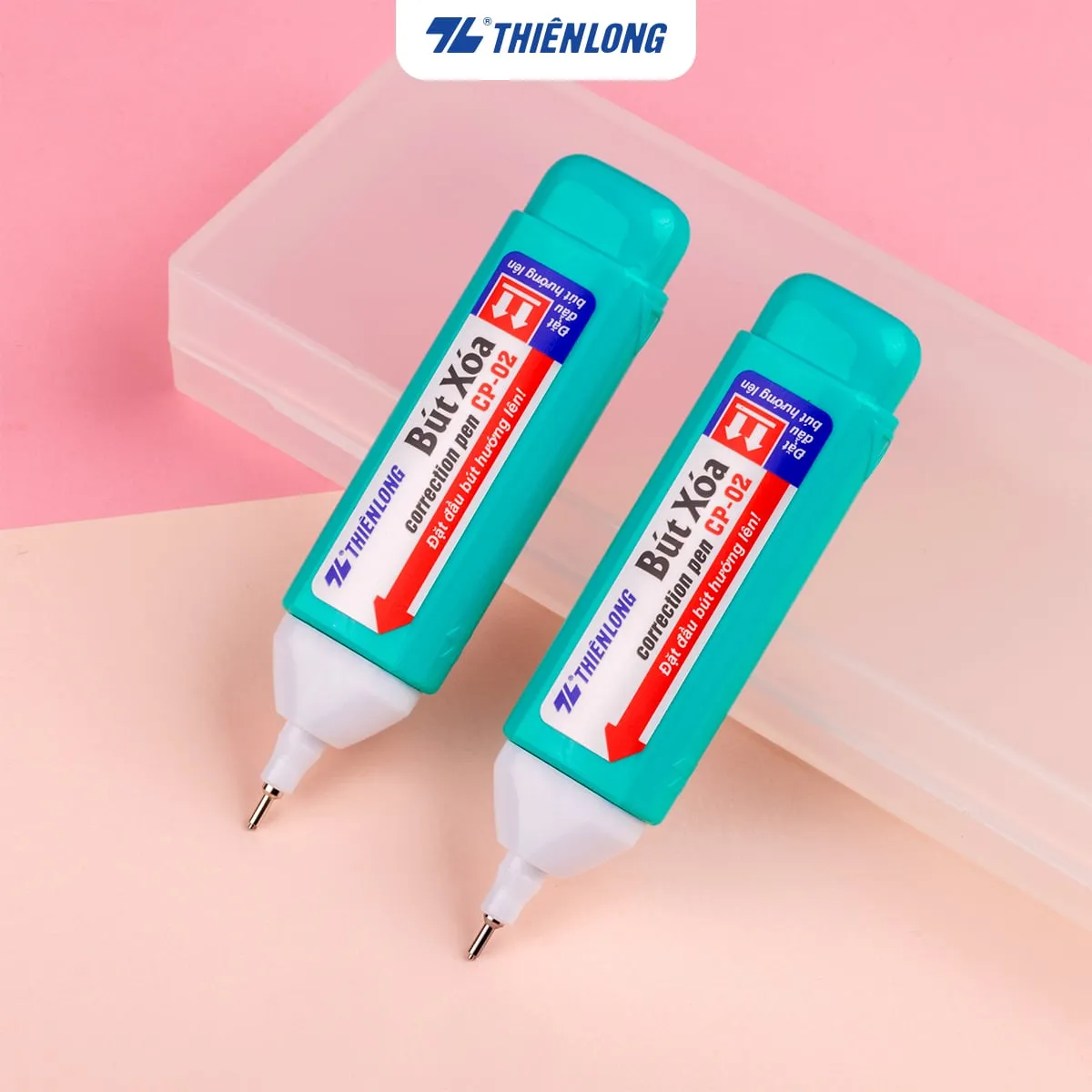 Hai cây bút xóa Thiên Long CP-02 thân xanh lá tươi sáng đặt trên khay nhựa nền hồng.
