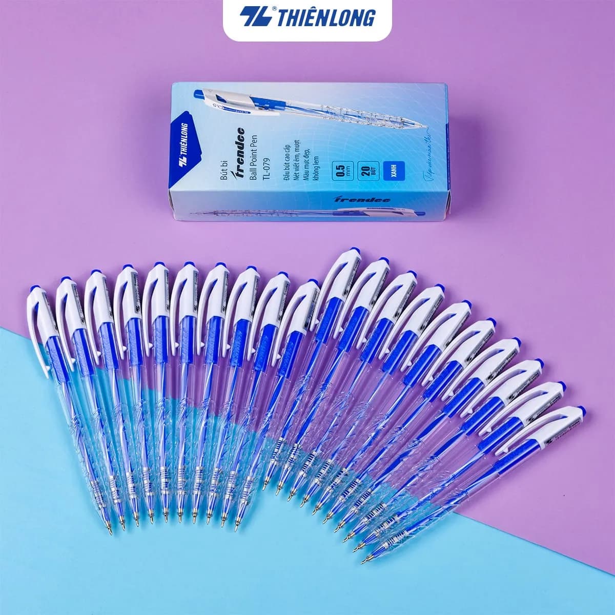 Hộp bút bi Thiên Long TL-079 0.5mm mực xanh và nhiều chiếc bút xếp hình quạt trên nền màu tím nhạt và xanh dương.