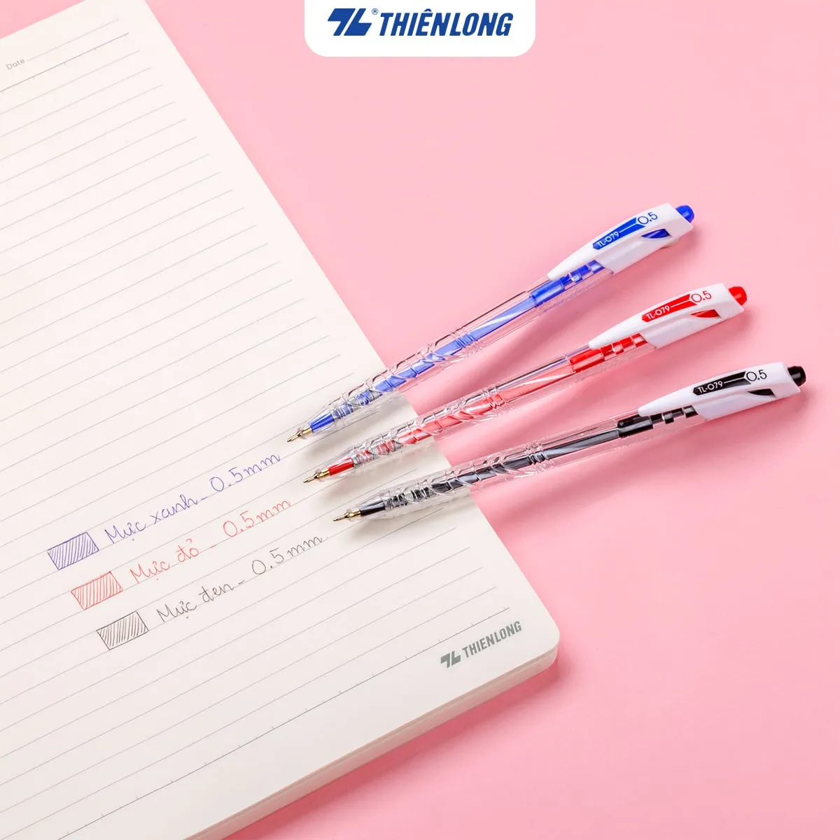Bộ ba bút bi Thiên Long TL-079 0.5mm màu xanh, đỏ, đen đặt trên cuốn sổ ghi chép.