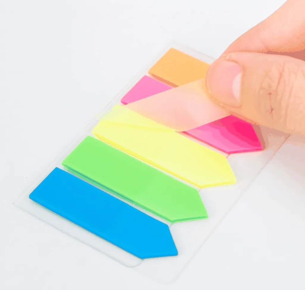 Ngón tay đang lấy một tờ giấy phân trang Deli màu sắc rực rỡ khỏi bảng dán tiện lợi.