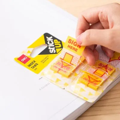 giấy phân trang deli có in chữ Sign Here đang được tay người dùng lấy ra khỏi vỉ để dán vào tài liệu.