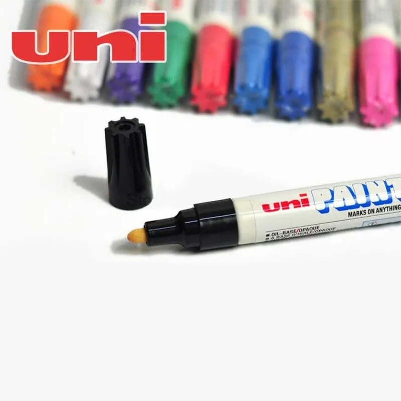 Bút sơn uni PX-20 màu trắng đang mở nắp cùng dàn bút nhiều màu sắc phía sau trên nền trắng