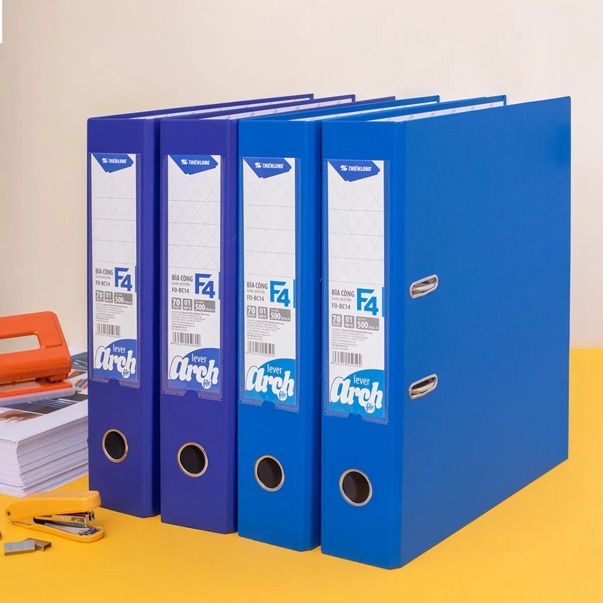 Bốn chiếc file còng bật Flexoffice màu xanh dương dùng để lưu trữ tài liệu khổ F4 ngăn nắp trên bàn làm việc